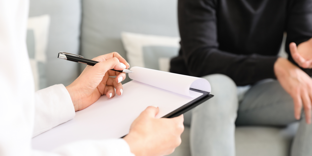 Counsellor taking notes in a supportive session